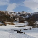 Snowy Loughrigg Tarn at the foot of Loughrigg Fell, Lake District