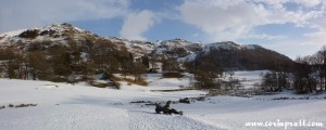Snowy Loughrigg Tarn at the foot of Loughrigg Fell, Lake District