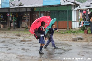 School children farewells in the rain, Yuksom, Sikkim, India